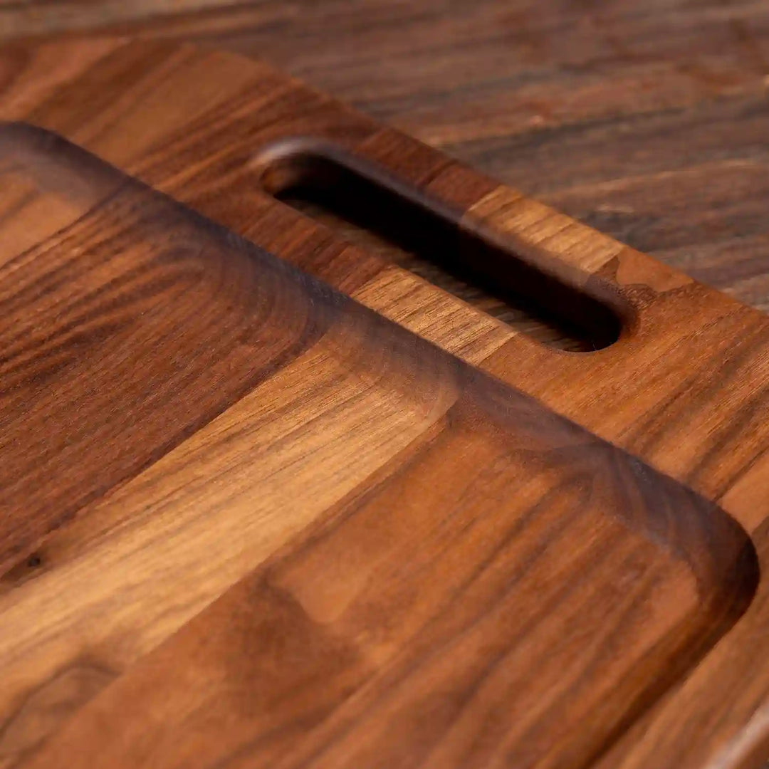 Walnut Barbecue Board with handles. Close up of handle and raise edge.
